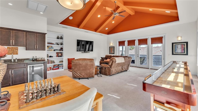 interior space with indoor wet bar, beam ceiling, high vaulted ceiling, wine cooler, and light carpet