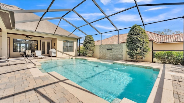 view of swimming pool with a patio, a lanai, and ceiling fan