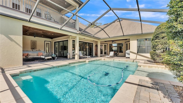 view of swimming pool with an outdoor living space, a lanai, ceiling fan, and a patio area