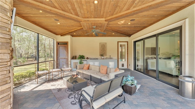 sunroom / solarium with vaulted ceiling, wooden ceiling, and ceiling fan