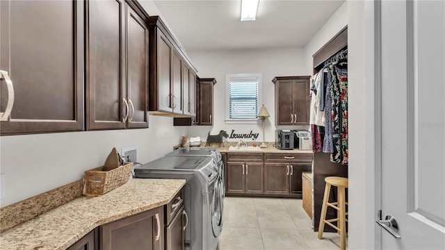 washroom with cabinets, sink, washer and dryer, and light tile patterned floors