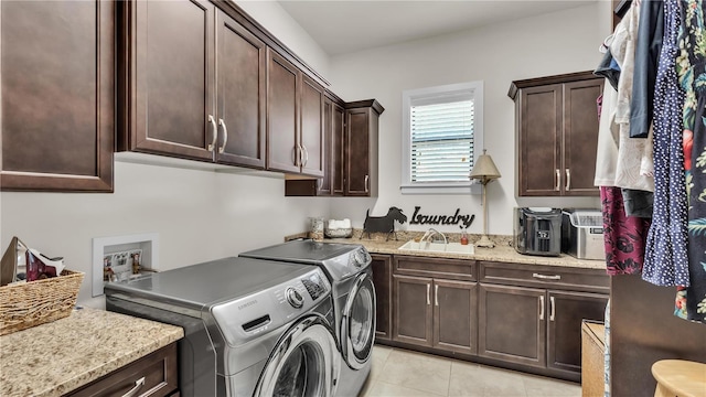 laundry area featuring light tile patterned flooring, cabinets, washer and clothes dryer, and sink