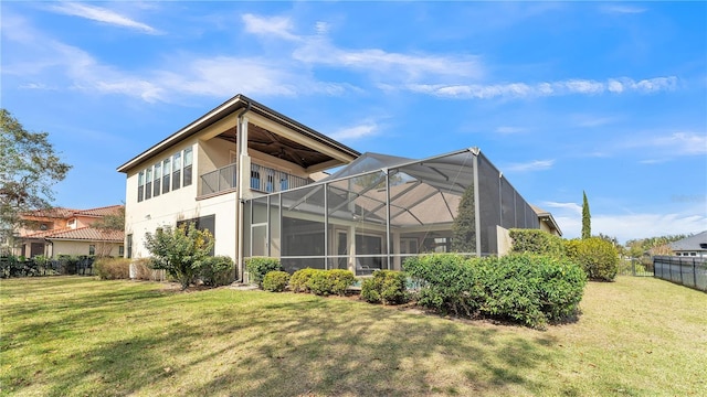 back of house featuring a lawn and ceiling fan