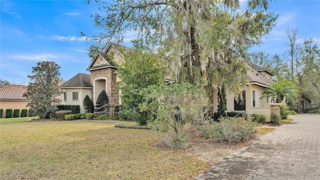 obstructed view of property with a front lawn