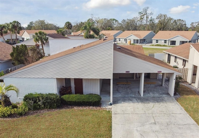 view of front of property with a carport and a front lawn