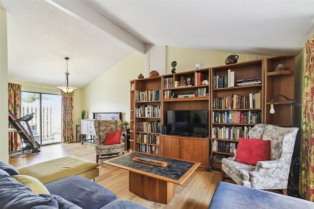 living room featuring lofted ceiling with beams, a textured ceiling, and light hardwood / wood-style flooring