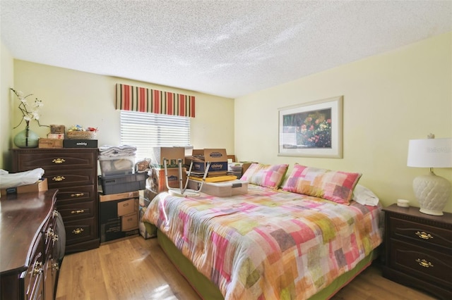 bedroom featuring light hardwood / wood-style flooring and a textured ceiling