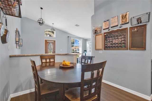 dining room featuring hardwood / wood-style flooring and vaulted ceiling