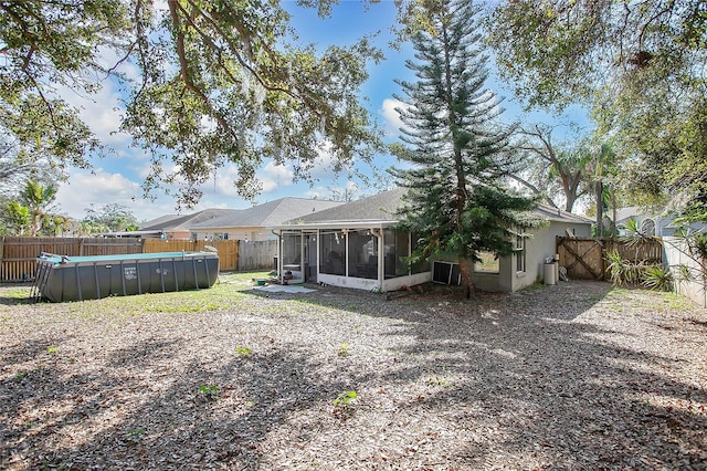 back of house with a fenced in pool and a sunroom