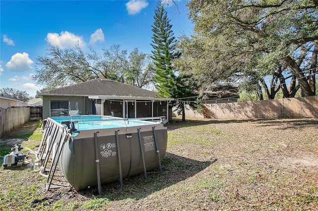 view of yard with a fenced in pool and a sunroom