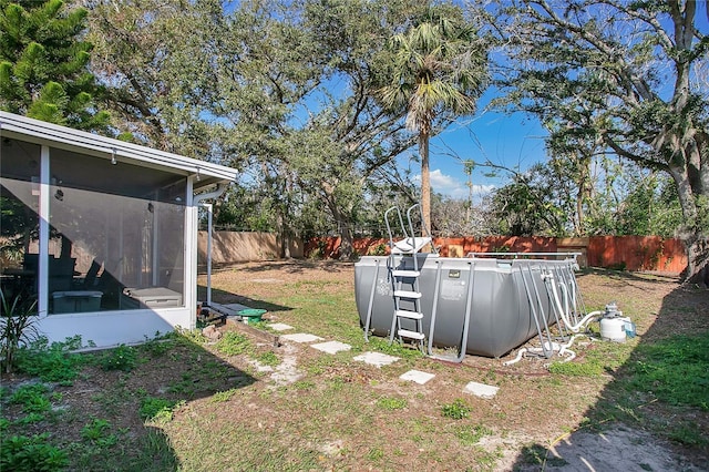 view of yard featuring a pool and a sunroom