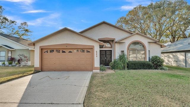 ranch-style home with a garage, a front yard, and french doors