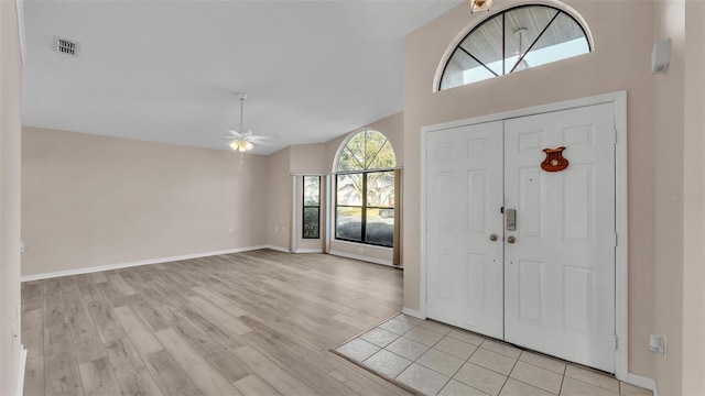 foyer featuring ceiling fan, lofted ceiling, and light wood-type flooring