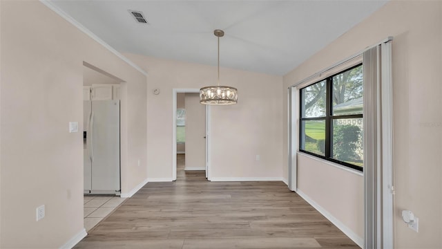 unfurnished dining area featuring lofted ceiling, a notable chandelier, and light hardwood / wood-style flooring