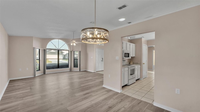 kitchen featuring decorative light fixtures, white cabinets, a chandelier, light hardwood / wood-style floors, and white appliances