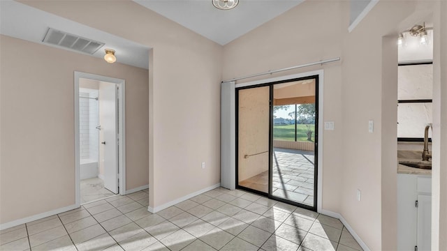 interior space featuring light tile patterned flooring, lofted ceiling, and sink