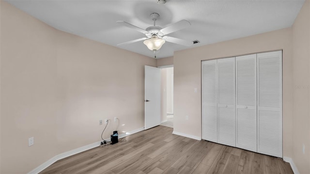 unfurnished bedroom with ceiling fan, a closet, and light hardwood / wood-style flooring