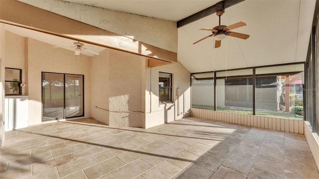 unfurnished sunroom featuring vaulted ceiling with beams and ceiling fan