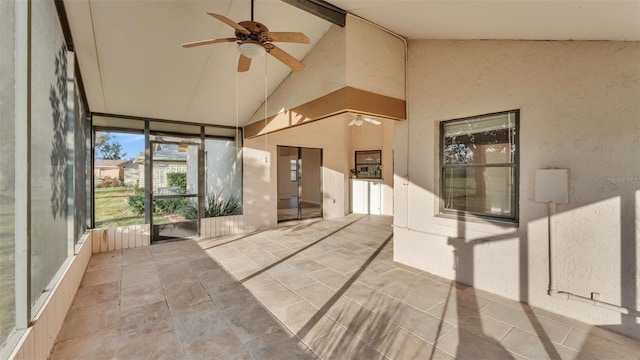 unfurnished sunroom featuring vaulted ceiling with beams and ceiling fan