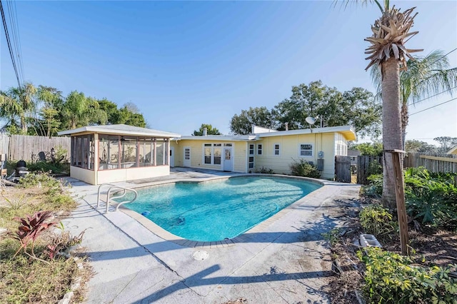 view of swimming pool featuring a patio and a sunroom