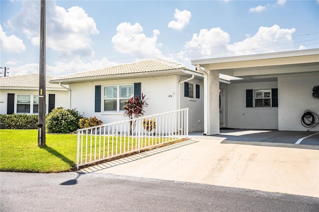 view of front facade featuring a front lawn and a carport