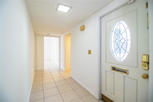 entrance foyer with light tile patterned floors and baseboards