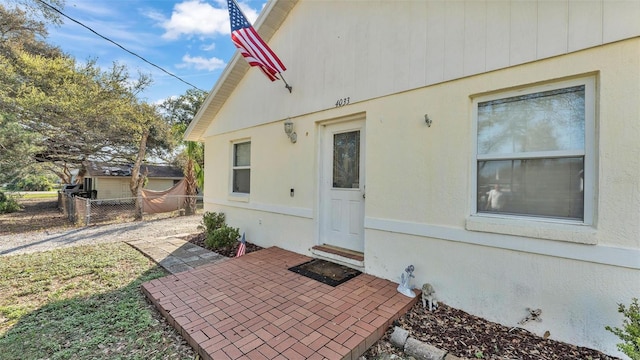 doorway to property featuring a patio area and fence