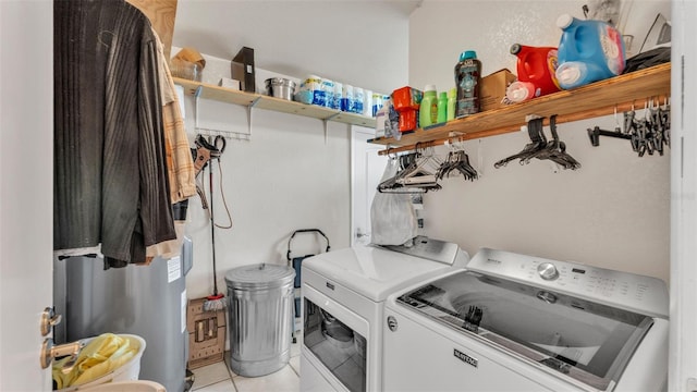 laundry room with laundry area, washing machine and dryer, and light tile patterned floors