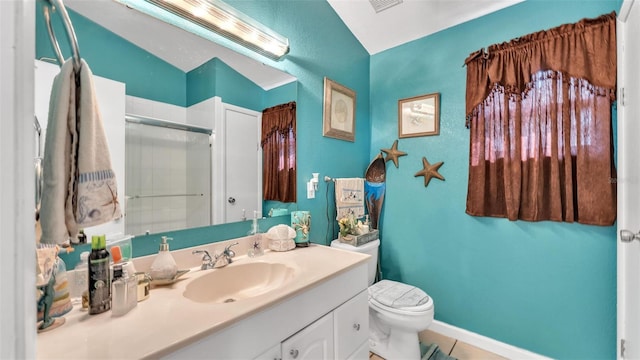 bathroom featuring toilet, vanity, a shower with door, and baseboards