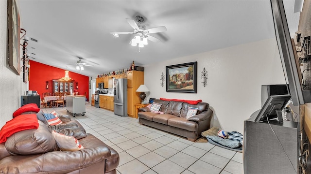 living area with a ceiling fan, lofted ceiling, and light tile patterned flooring