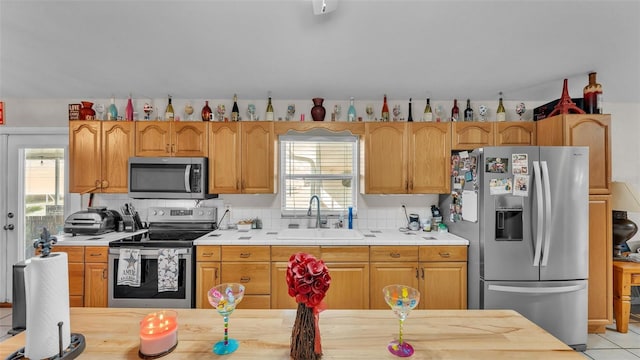 kitchen featuring a healthy amount of sunlight, stainless steel appliances, a sink, and light countertops