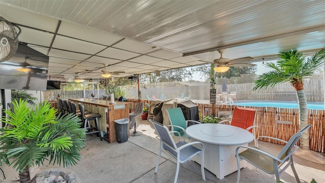 view of patio / terrace with ceiling fan, a fenced backyard, a grill, outdoor dry bar, and outdoor dining space