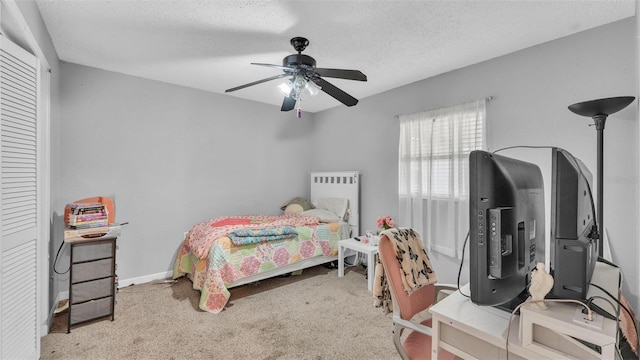 bedroom featuring baseboards, a textured ceiling, a ceiling fan, and carpet flooring