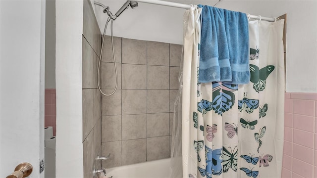 full bathroom featuring tile walls and shower / tub combo with curtain