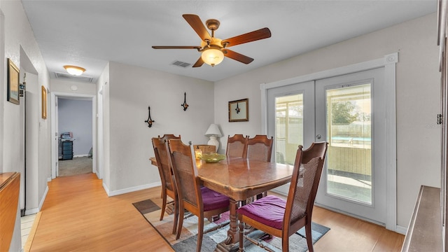 dining room with french doors, light wood-type flooring, visible vents, and baseboards