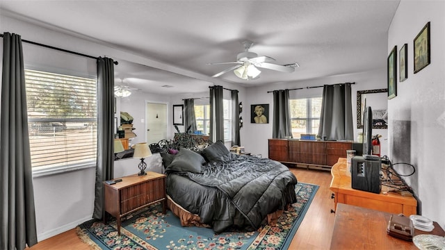 bedroom featuring ceiling fan, wood finished floors, and baseboards