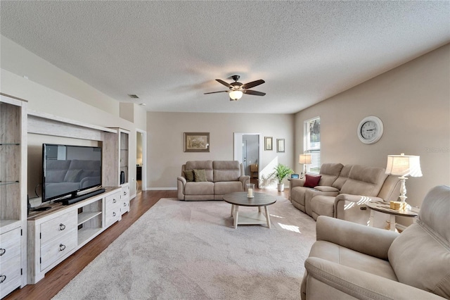 living room with dark hardwood / wood-style floors, a textured ceiling, and ceiling fan