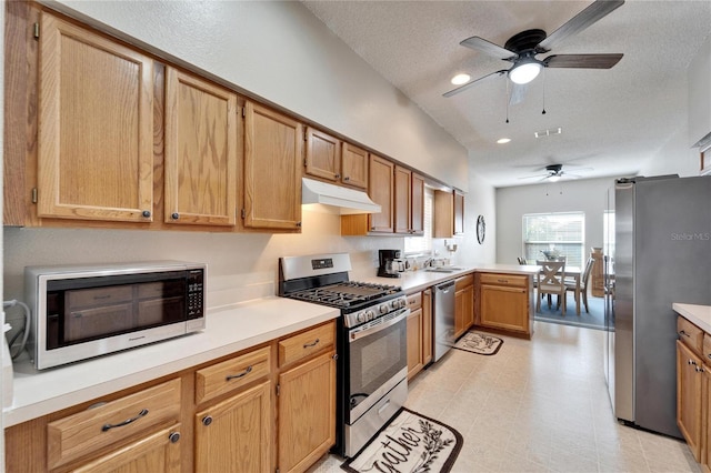 kitchen featuring sink, a textured ceiling, kitchen peninsula, ceiling fan, and stainless steel appliances