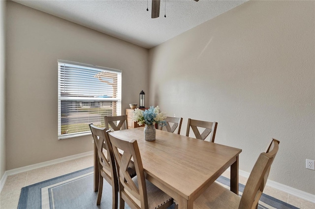 tiled dining area featuring ceiling fan and a textured ceiling