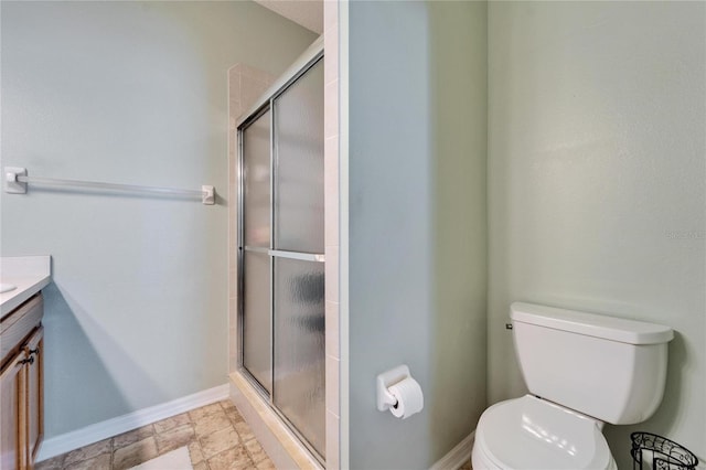 bathroom featuring vanity, an enclosed shower, and toilet