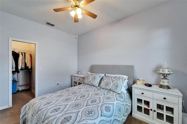 carpeted bedroom featuring ceiling fan, a spacious closet, and a closet