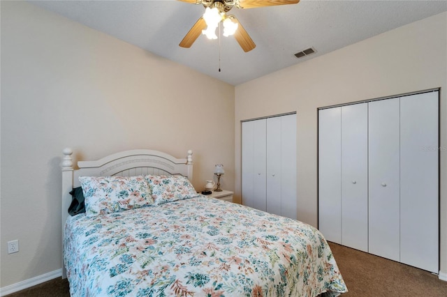 bedroom with multiple closets, ceiling fan, and dark carpet