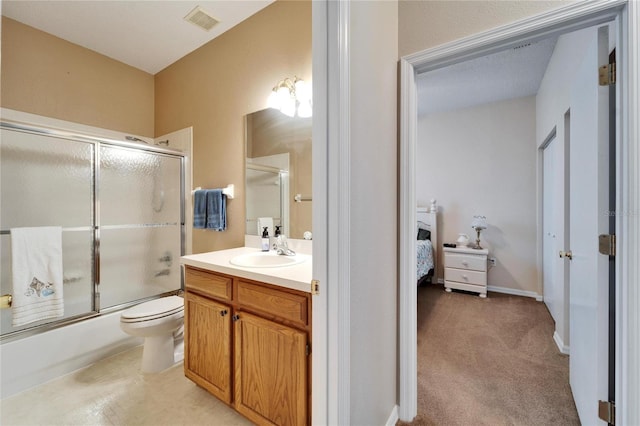 full bathroom featuring vanity, bath / shower combo with glass door, and toilet