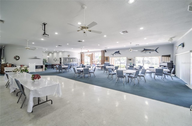 dining area featuring ceiling fan and a textured ceiling