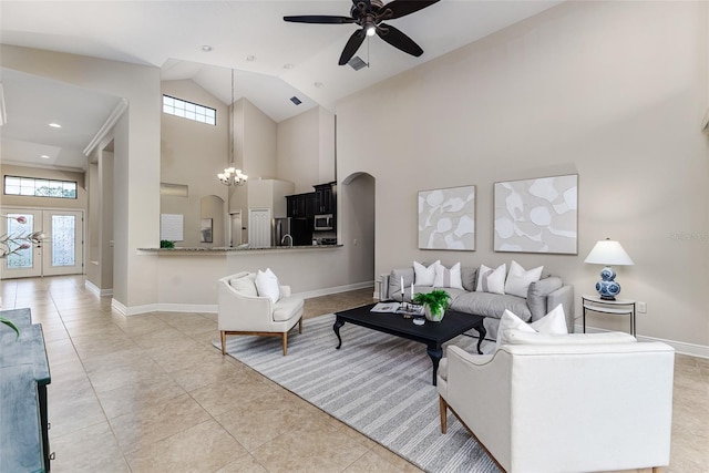 living room featuring ceiling fan with notable chandelier, high vaulted ceiling, and light tile patterned floors