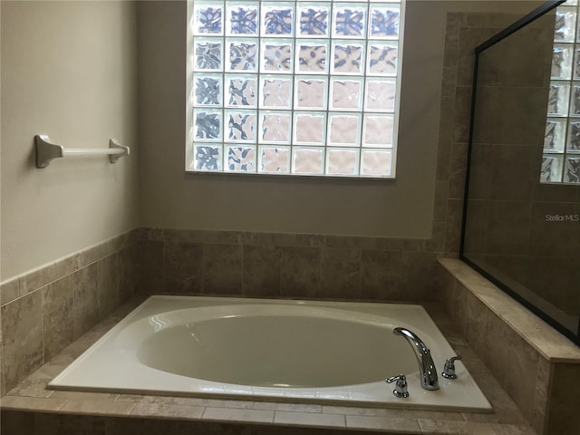 bathroom with a relaxing tiled tub