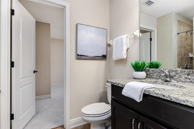 bathroom featuring vanity, toilet, and a shower