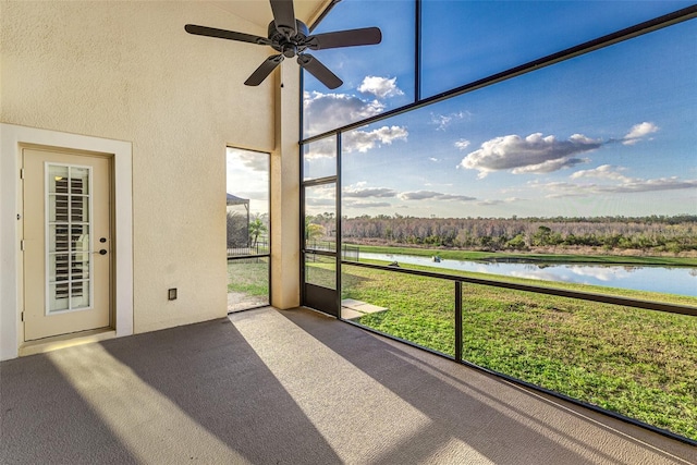 unfurnished sunroom with a water view and ceiling fan