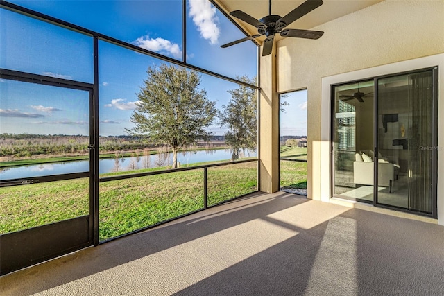 unfurnished sunroom featuring a water view and ceiling fan