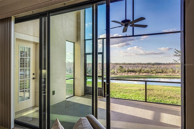 doorway featuring ceiling fan, a healthy amount of sunlight, and a water view